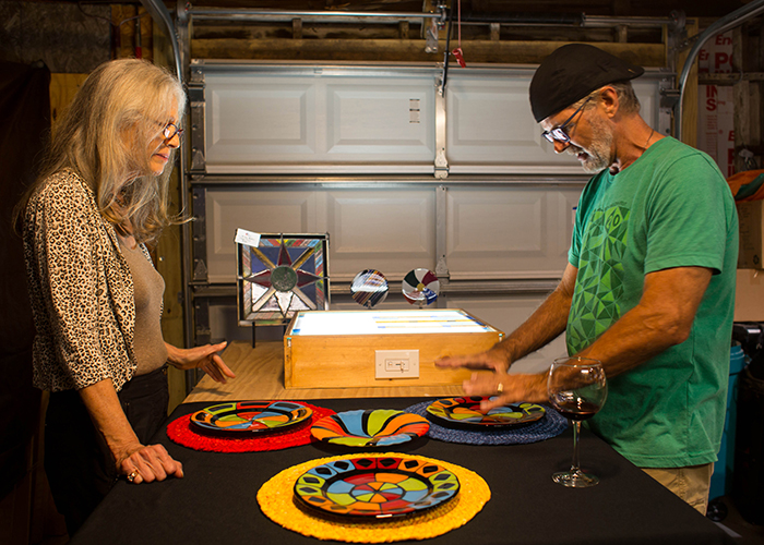 Kim Alderman, left, a collage, sculptural ceramics, and wearable artist, views Michael Baker's fused glass plates.