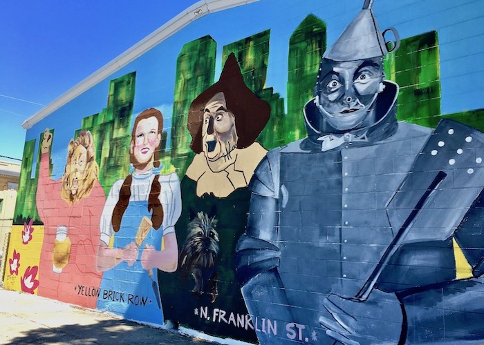 A whimsical mural depicts Yellow Brick Row in Tampa Heights.