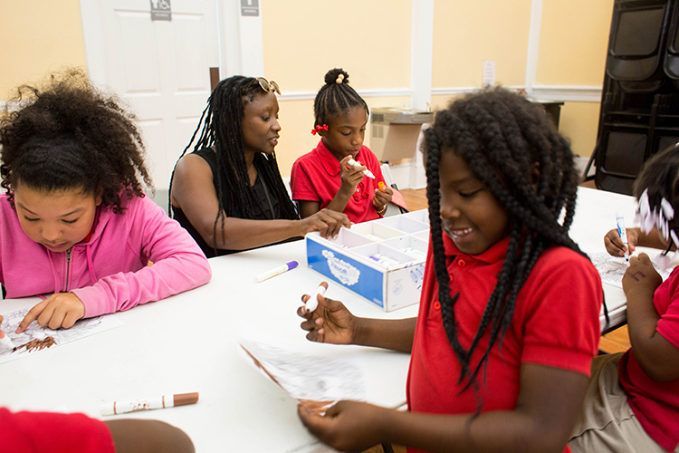 Sonia Coleman, center, with Cultural Exchange Lyfe-Stile Network works with students.