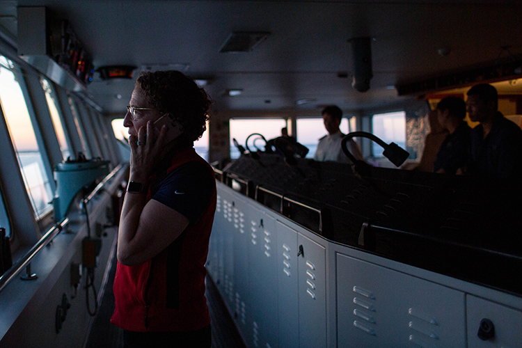 Harbor Pilot Carolyn Kurtz calls in tug boats to help slow the vessel as it brings in 3,000 shipping containers.