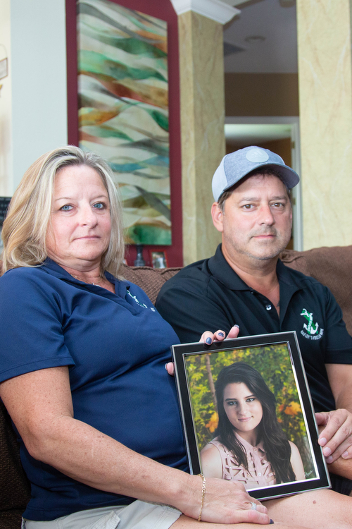 Lisa and Chris Acierno hold a picture of their daughter Hailey who died from suicide.