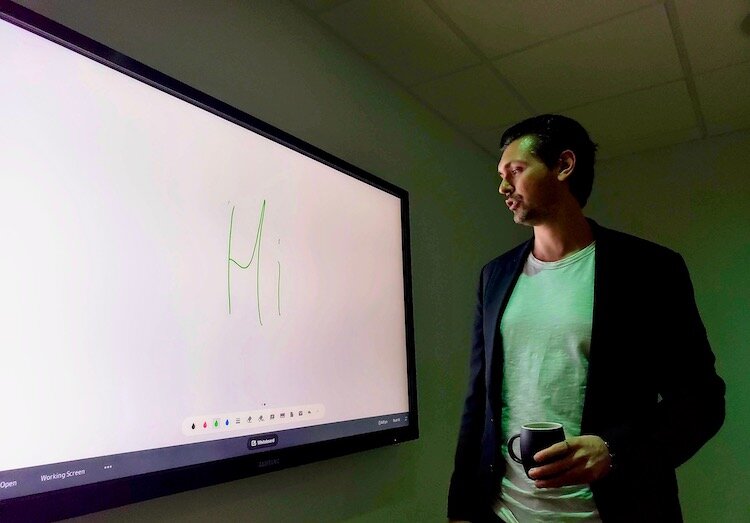 The Ring CEO Daniels Ikajevs demonstrates an electronic presentation panel in co-working space..