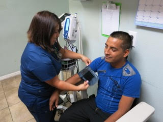 Carolina Galván, physician assistant, checks Gelacio Pacheco’s vital signs at the Suncoast Community Health Center in Wimauma.