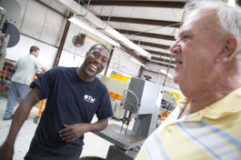 Welder Carlos Betts and CEO Dick Peck share a laugh. 