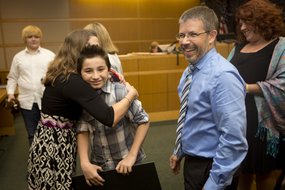 Mathew Kenty gets a hug from Heart Gallery's Tiffany Faykus. 