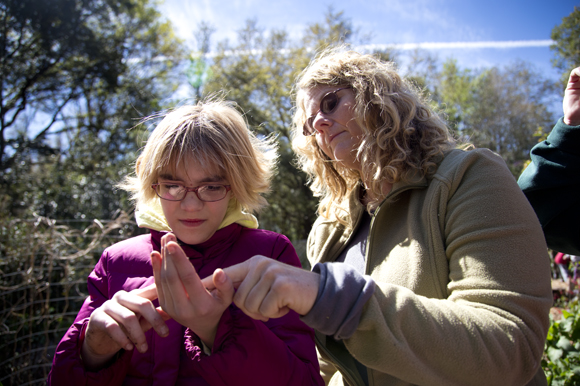 Teacher Beth Calcaterra and a student discuss the anatomy of a worm found in the school garden. 