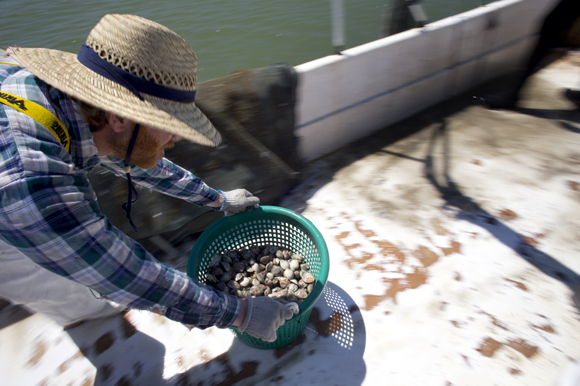 Aaron Welch III moves a bucket of across the boat after cleaning them. 