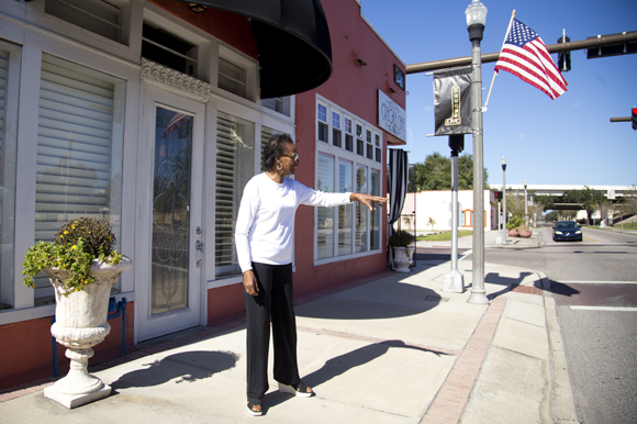 Carolyn Brayboy waves to a neighbor outside of Chief's Creole Cafe. 