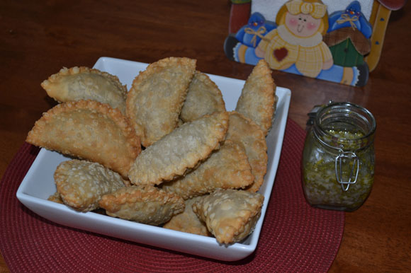The family now cooks  empanadas  at home. Colombia's quintessential street food is  shown here with the spicy sauce aji.