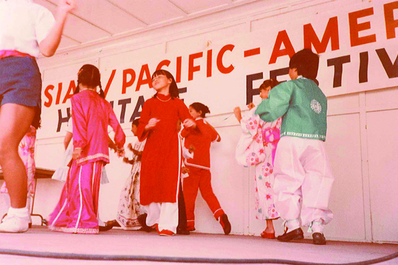 Wearing a red ao dai, the traditional Vietnamese dress, Phuong dances at an Asian Pacific American Heritage Festival in St. Petersburg.