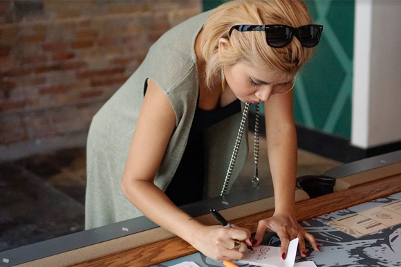 Sophia Sanh, founder of Sweet Rebel Boutique, signs in for the Tampa Bay Startup Week happy hour party.