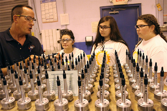 SMT supervisor Dale Lynn shows Marshall Middle School students an assembly that goes into the magneto on a piston engine aircraft. 