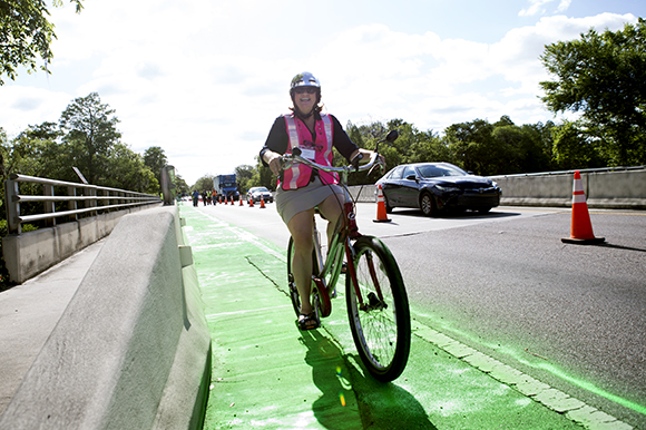 Founder & Principal, Pedal Power Promoters, Christine Acosta bikes the new green on Bullard Parkway.
