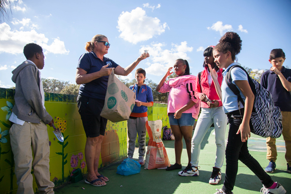 Kerri Battishill-Ladd directs students in planting beans, integrating art in learning agriculture.