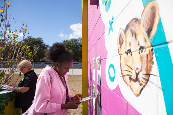 Artist Pete Lawson, far left, mixes paint for touch ups in 'Art Meets Ag' as a student studies. 