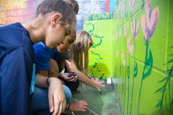 Student ambassadors paint roots during a plant identification lesson. 