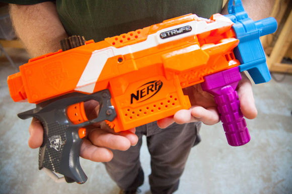 Bryan Lee holds a toy gun he made using a 3-D printer inside the 'Gym for Nerds' at Hackerspace.