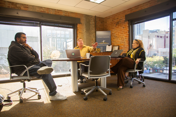 Richard Munassi, left, talks with Tom Coffin and Anne Devlin of Simply Reliable at Tampa Bay Wave. 