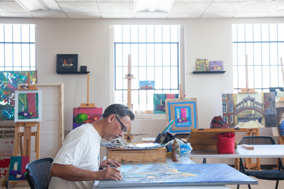 Alberto Chirinos paints in art class at the Roberta M. Golding Visual Arts Center.