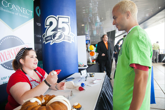 Kayla Freed of Kayla's Kitchen talks with Jason Jazzar due to interest in her baking products at the Innovation Expo at the Synapse Summit in Tampa.