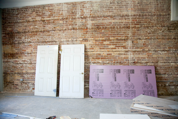 Exposed brick at a building being renovated for marketing, design, and a brew pub retail space.
