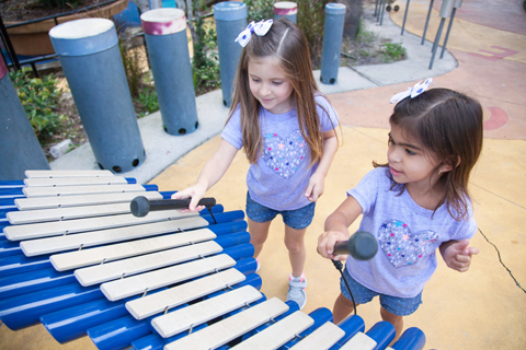 Mia and Maite experiment with sounds in the children's playground at Macfarlane Park.