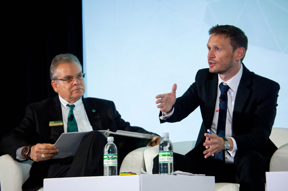 Paul Sanberg, left, listens as Cédric Denis-Rémis, vice pres., of development, at PSL University in France gives a talk at the Young Universities Summit.