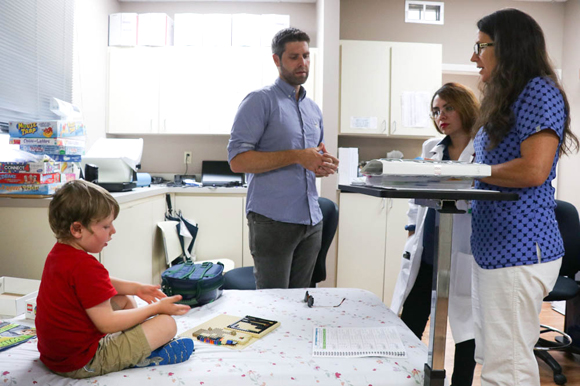 Harry Coleman IV, left, a peanut allergy patient, plays as his dad Harry Coleman III, talks with Claudia Gaefke and Michelle Twitmyer at USF's Div., of Allergy and Immunology Clinical Research Unit.