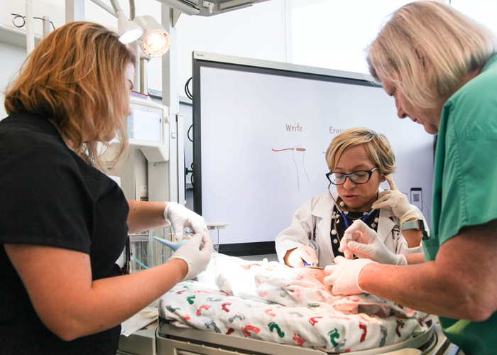 Dr., Jennifer Arnold and staff show how the simulation center works in the case of a high-risk delivery. 