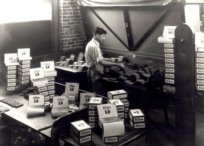 Interior of the Santaella cigar factory showing a worker boxing cigars in 1935.