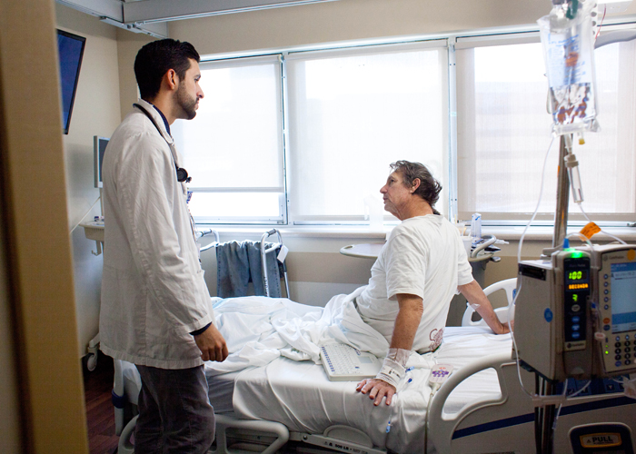 Jesus Diaz Vera, left, informs long-term patient David Pimms that he will be released from the hospital in three days.