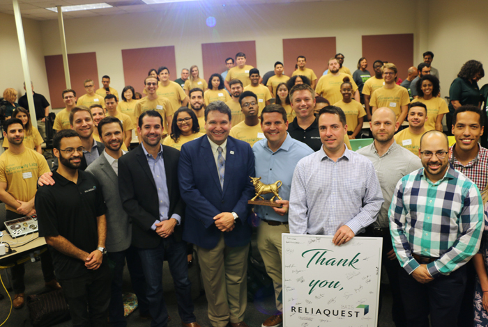 ReliaQuest executives and Dean Moez Limayem pose for a photo with students in the inaugural course.