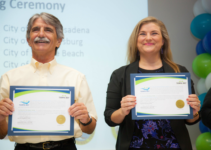 Al Johnson, Mayor of St. Pete Beach and Brandi Gabbard for the City of St. Pete hold up their signatures to join the Tampa Bay Regional Resiliency Coalition (TBRRC).