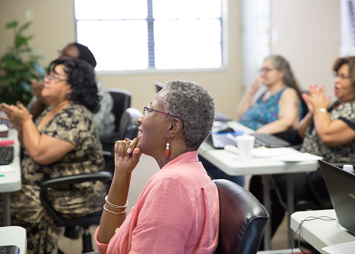 Dina Rhone, in the foreground, sits in an ACT classroom.