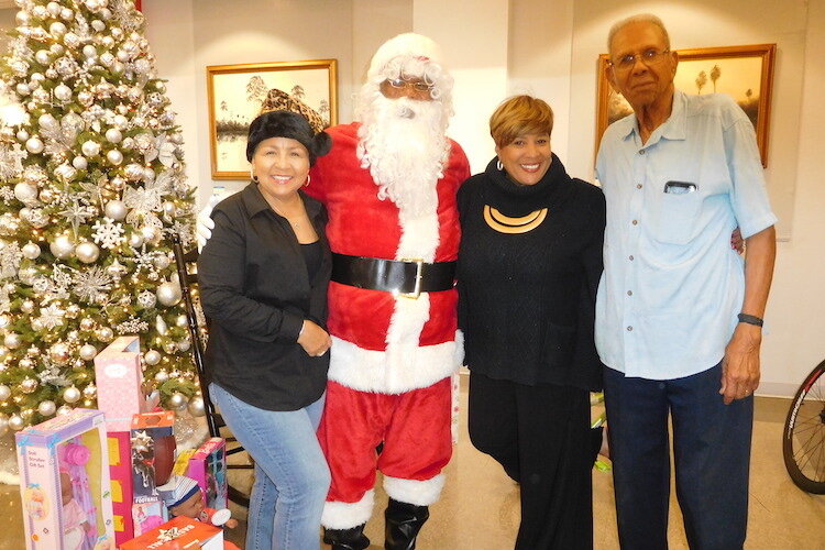 Dana Battle, Woodson Museum board chair, with Santa; Terri Lipsey Scott, executive director; and David McEachern, retired board member of the YMCA.