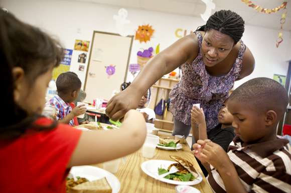 Teacher Kendra Alexander helps out during lunchtime. - Julie Branaman