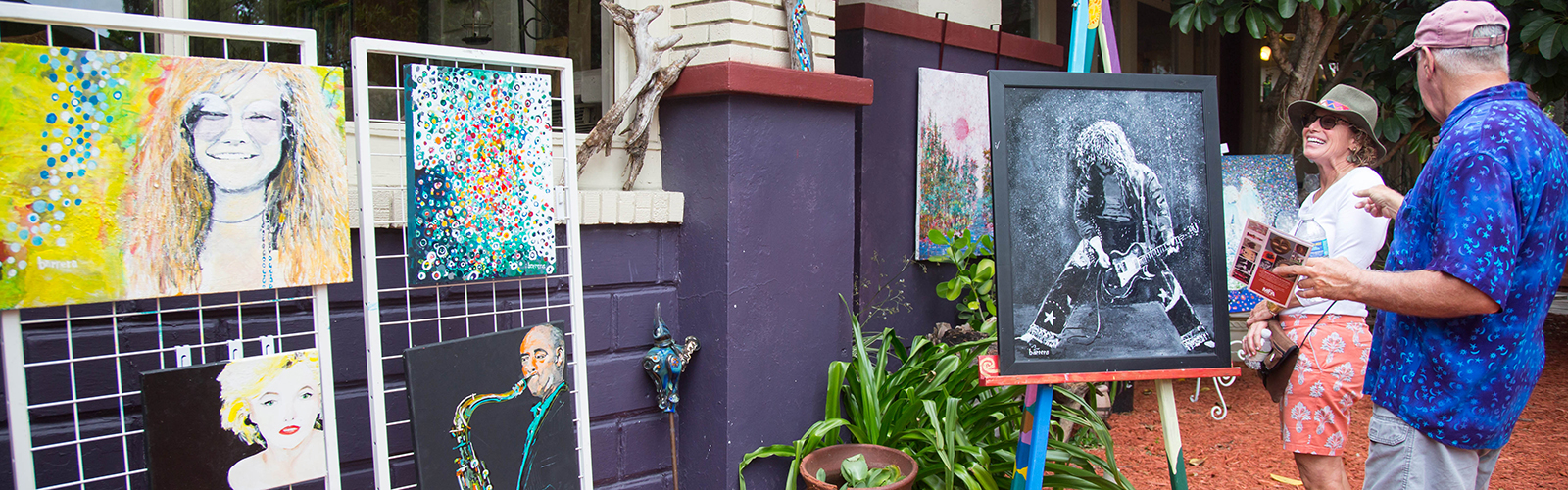 Guests view paintings by Paul Barrera in his yard at the Artist Enclave of Historic Kenwood's "Artists at Work Tour".