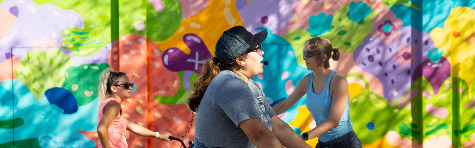 Riki Tarr, left, Monica DeChaine, and Hillary Hepp check out art by Jujmo, a Tampa Bay muralist known for her happy colors and cartoon-like style.