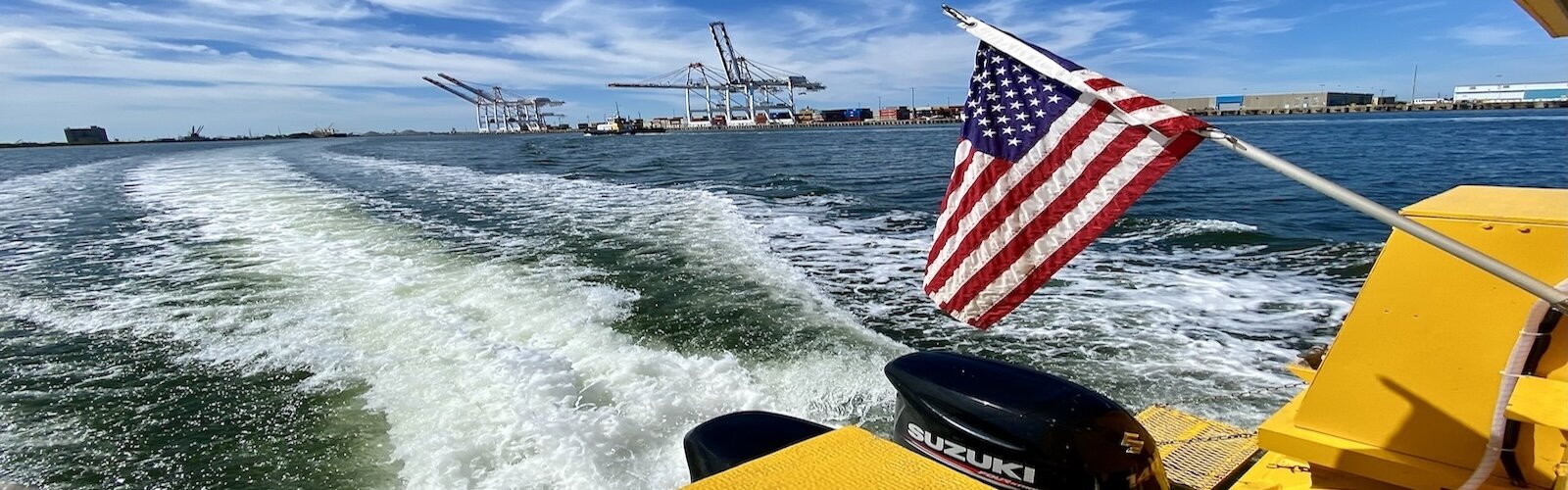 A Pirate Water Taxi creates a wake as it zips past gantry cranes used to offload cargo ships making port calls at Port Tampa Bay on McKay Bay.