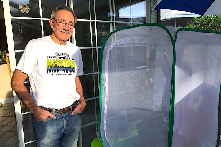 Bruce Shephard with cage for raising monarch caterpillars at his Tampa home on March 30, 2020.