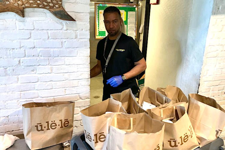 A staff member fills bags with food supplies at Ulele Restaurant in Tampa Heights to give to the restaurant’s furloughed employees.