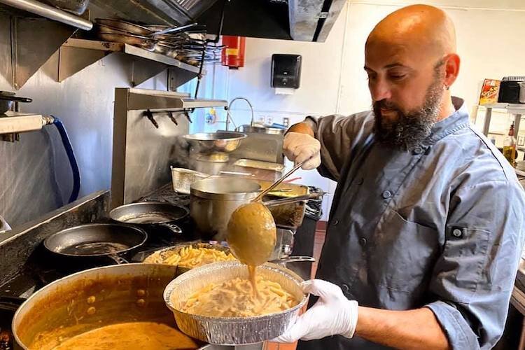 Tony Mangiafico, co-owner of Gratzzi Italian Grille, dishes out their famous mac & cheese for takeout.