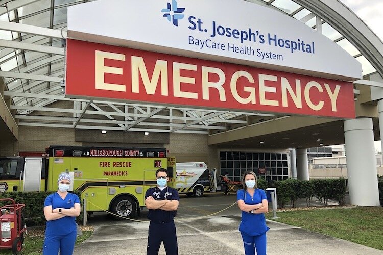 A team of healthcare workers greets visitors to the emergency room at St. Joseph's Hospital in Tampa.