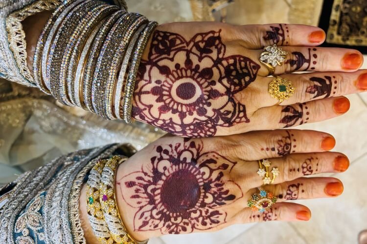 Henna tattoos and henna nail color are Eid must-haves for women. Notice the traditional bracelets, or bangles, as they are called.