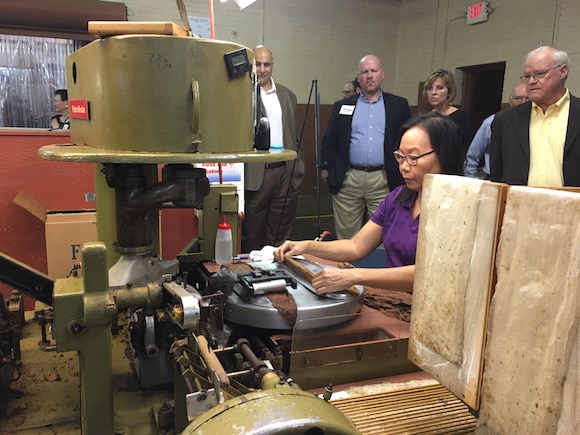 Supporters of Southeastern Guide Dogs watch a cigar being made.