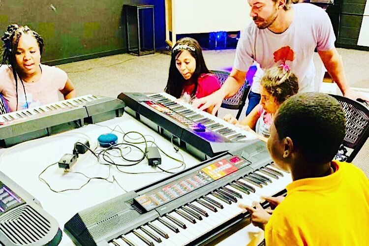 A group of keyboard students enjoy their group lesson.