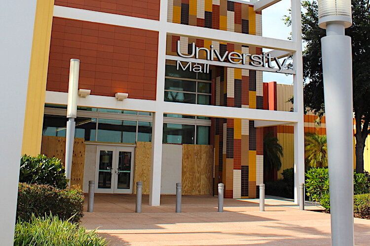 Boarded up windows at University Mall following looting.