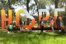 Local students and Uptown Tampa residents team up to paint a Hope sculpture in Harvest Hope Park.