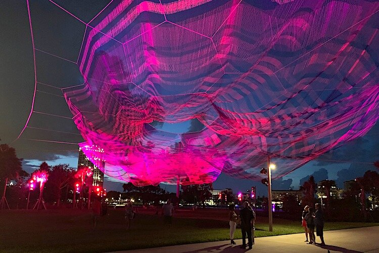 Bending Arc by Janet Echelman lit up at night at the new St. Pete Pier.