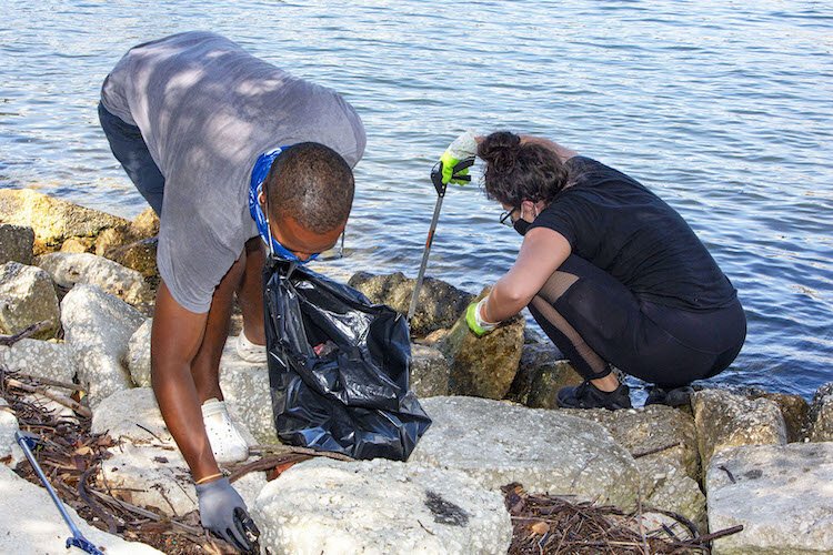 Holistic Waste Solutions' Kemlair Touloute (left) collects and weighs the debris before recycling and repurposing it.